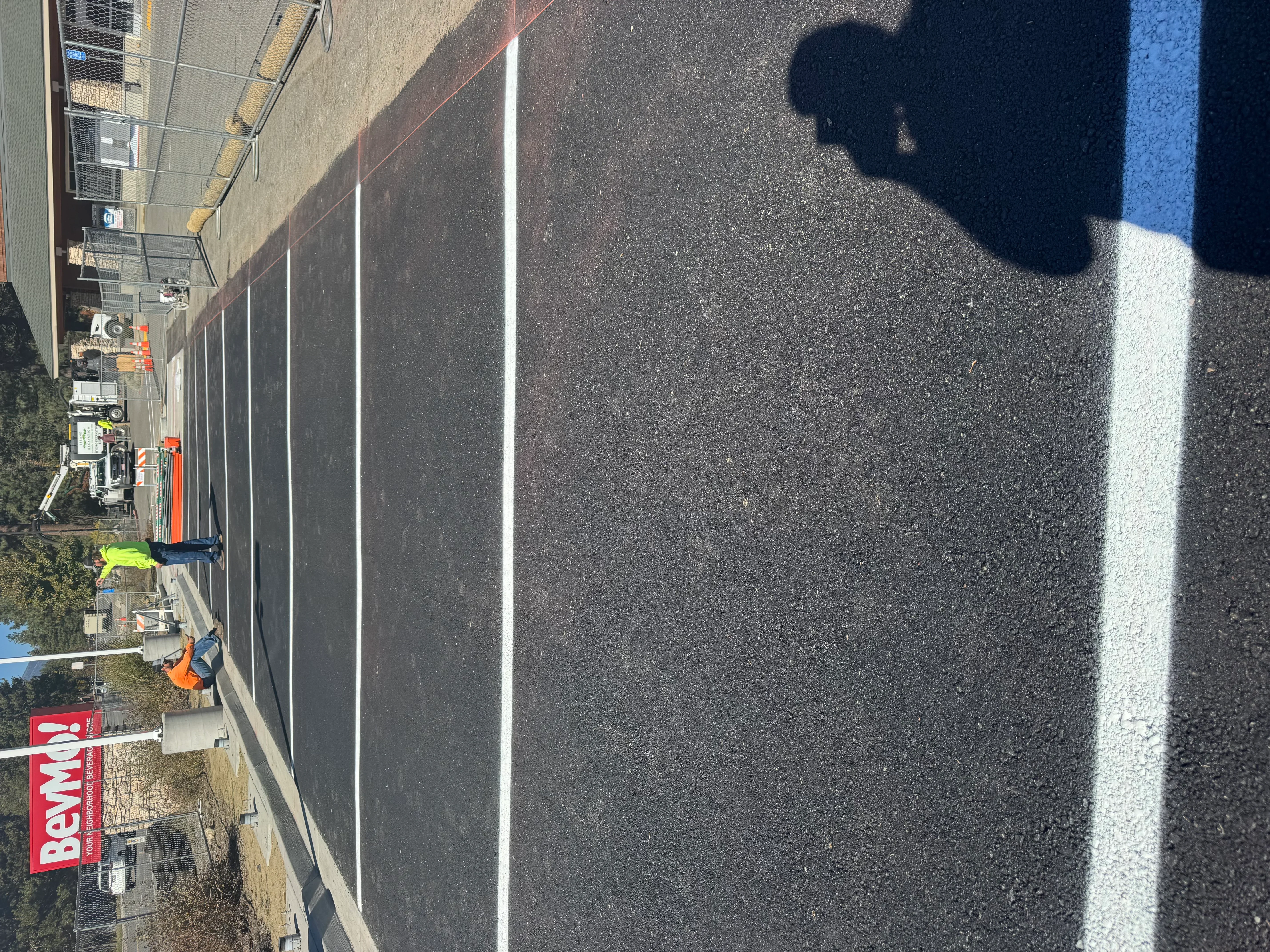 Newly paved commercial parking lot with white line markings and dark asphalt surface