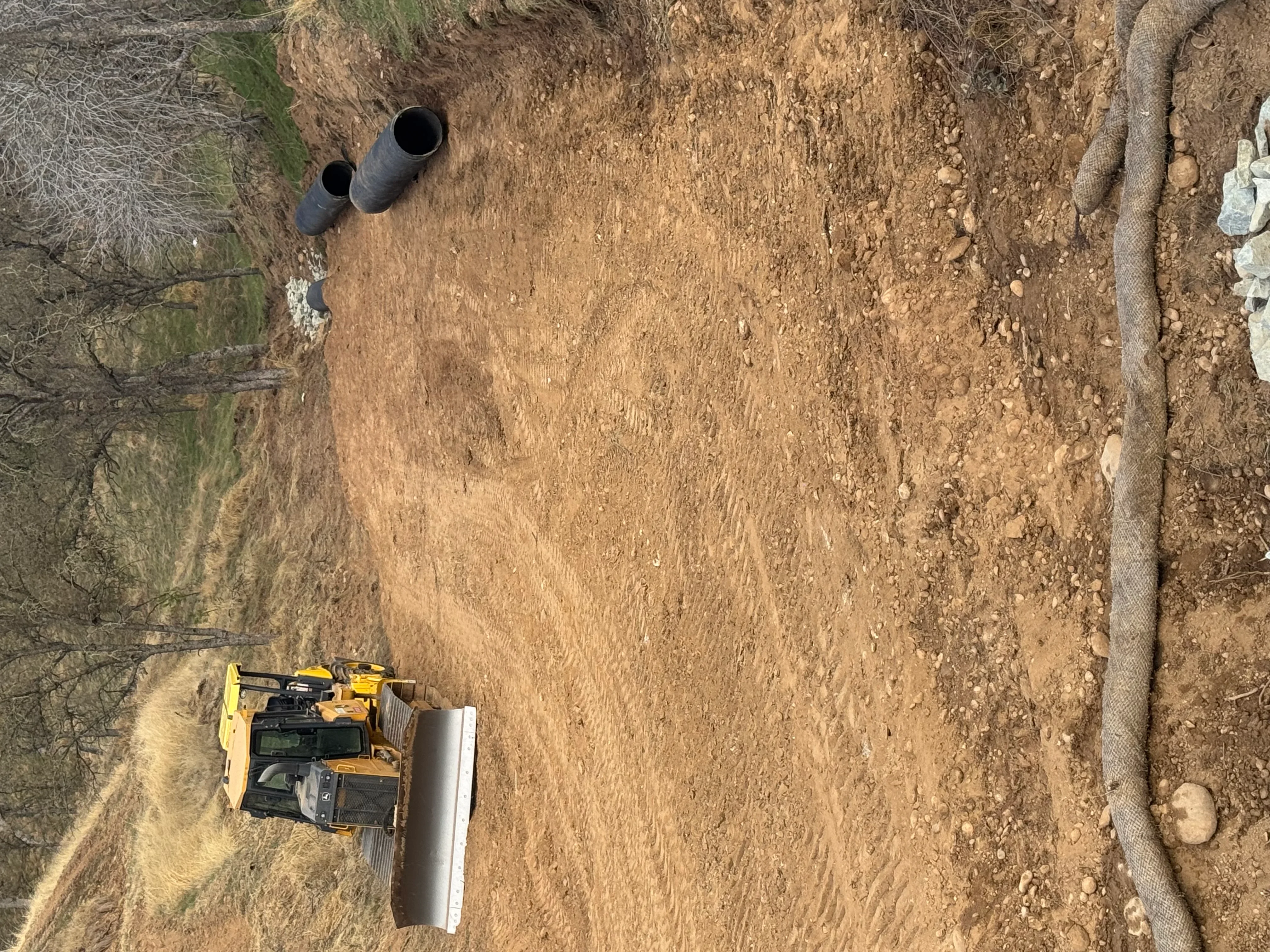 Drainage pipes and grading equipment on prepared construction site